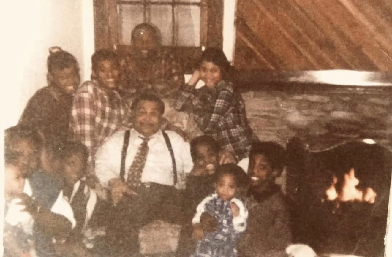 Vintage family photograph of children and adults gathered together by a lit fireplace